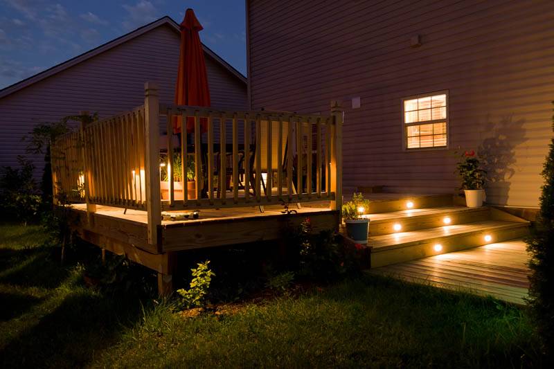 Wooden deck and patio of family home at night